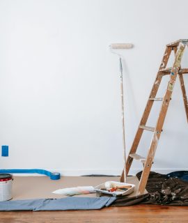 Escalera y pared de pintura con lonas debajo