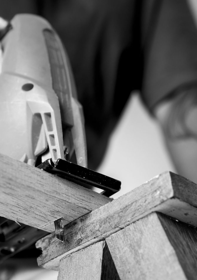 Hombre con herramienta cortando un tablón de madera
